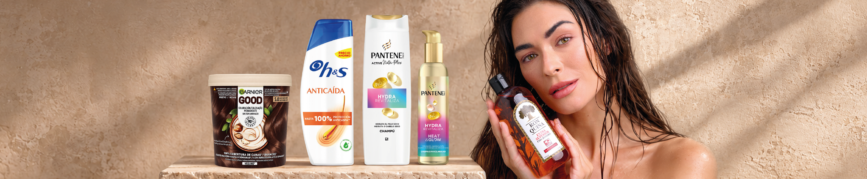 Imagen de cuidado capilar con una selección de productos para el cabello de las marcas Garnier, Ohes y Pantene. Incluye mascarilla capilar, champú anticaída, champú hidratante y sérum reparador sobre una superficie de piedra en tonos beige. A la derecha aparece una persona sosteniendo un producto capilar en un entorno de estética y cuidado personal.
